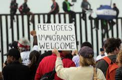 A girl holding a sign that says racism is also a pandemic.